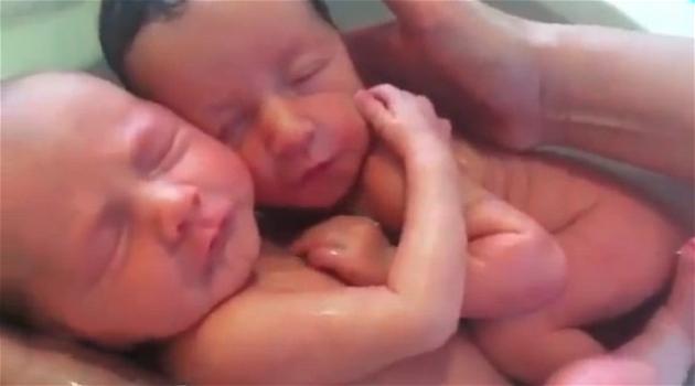 Gemellini neonati si abbracciano durante il bagnetto: il video che commuove il web
