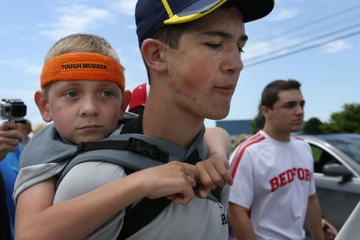 Il fratellino è paralizzato, 14enne lo porta in spalla per 64 km per sensibilizzare la gente