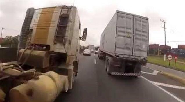 Questa moto sfreccia tra i camion incurante del pericolo