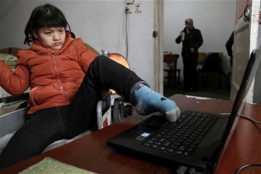 Pechino: ragazza paralizzata dalla nascita scrive un libro con il piede sinistro. Scrive 30 parole al minuto