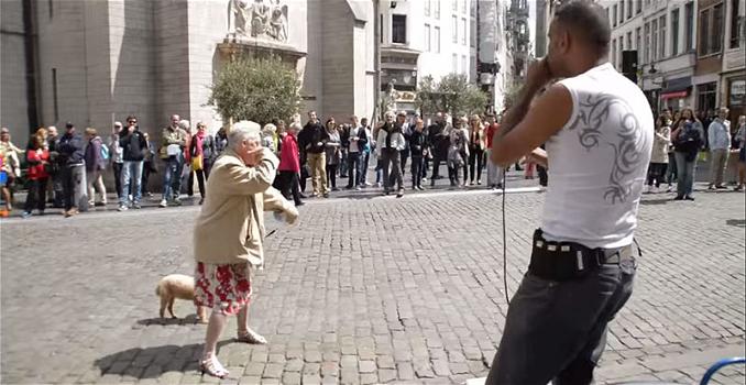 Un’anziana signora si ferma davanti ad un artista di strada. Ecco cosa fa