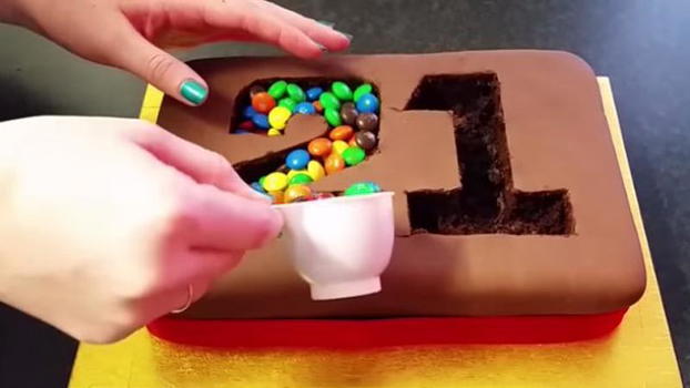 Mette degli smarties sulla torta. Il risultato è bellissimo!