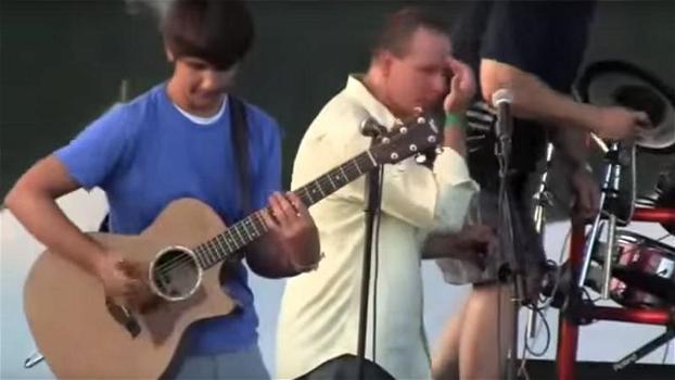 Ragazzo sale sul palco e inizia a suonare la chitarra in un modo insolito