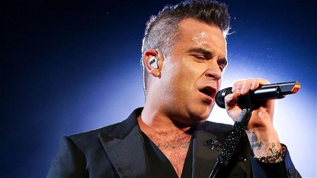 Robbie Williams stringe le mani alla folla, poi si disinfetta