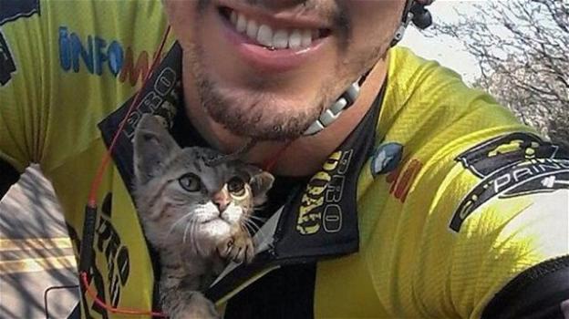 Ciclista salva un gattino dalla strada tenendolo sotto la maglia