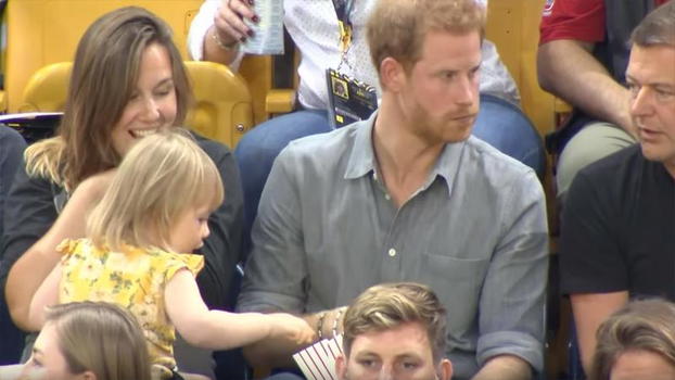 La bimba gli ruba i pop corn. La simpatica reazione del principe Harry fa ridere tutti!