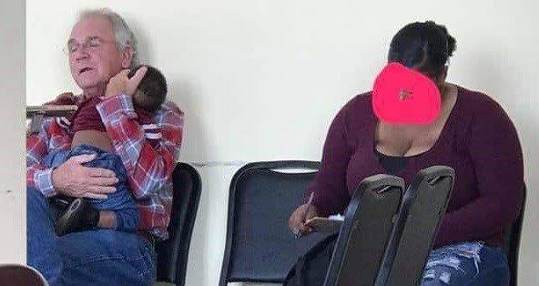Lo scatto di un anziano che culla un bimbo di colore è diventato virale: “Una speranza contro il razzismo”