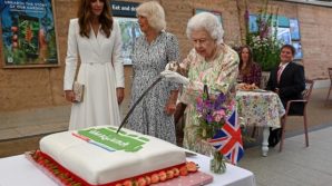 La Regina Elisabetta taglia la torta con una spada cerimoniale: