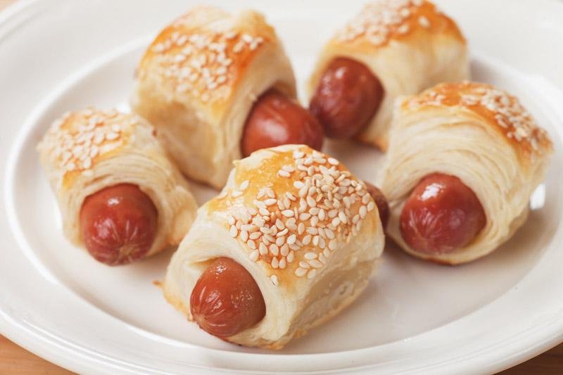 Pigs in blanket, sausage rolls with sesame covered puff pastry