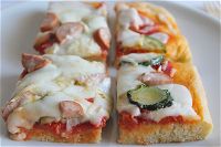 Pizza al taglio con zucchine, wurstel e scaglie di Parmigiano Reggiano
