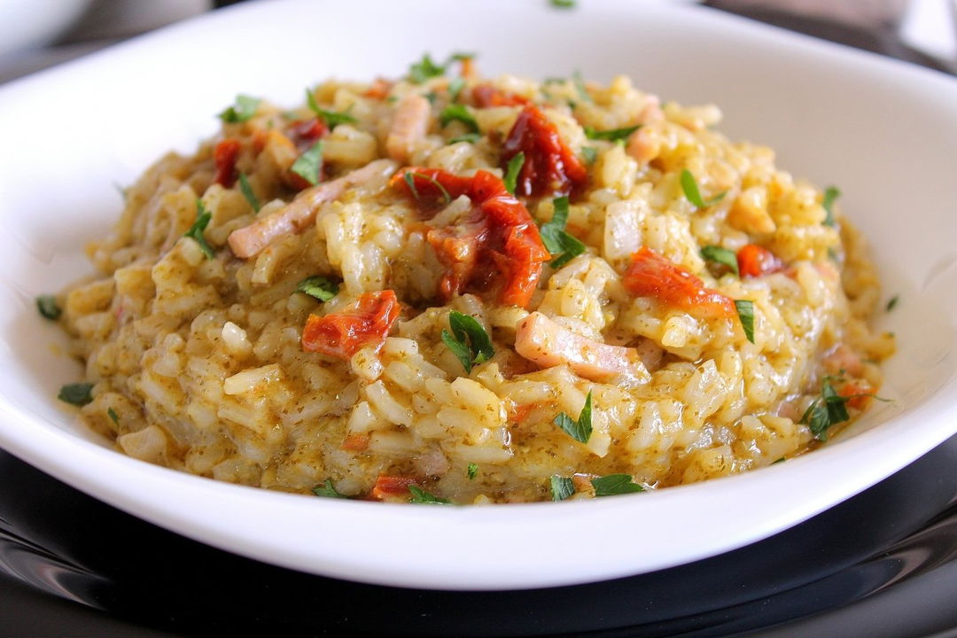 Risotto con pesto di rucola, pomodori secchi e prosciutto cotto