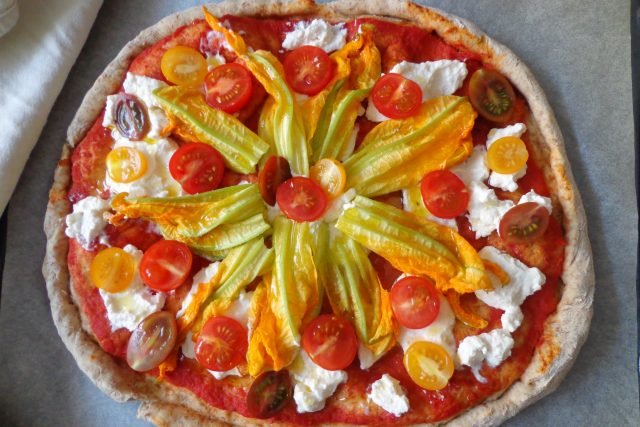 Pizza integrale con ricotta, pomodorini e fiori di zucca