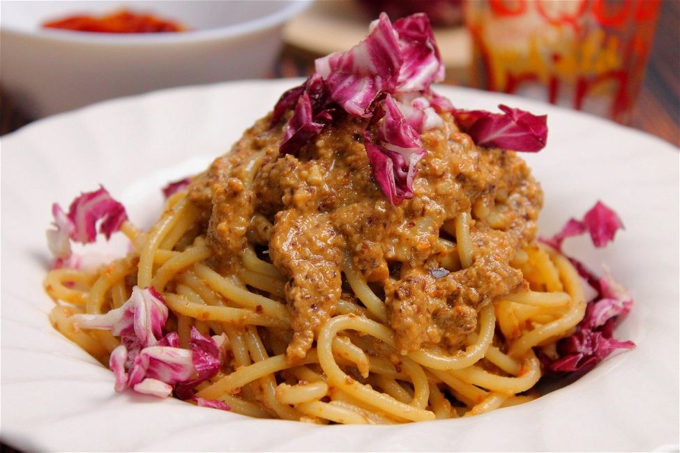 Spaghetti con pesto di radicchio, mandorle e pomodori secchi
