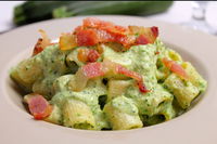 Mezzi rigatoni con pesto di zucchine, rucola, ricotta e guanciale