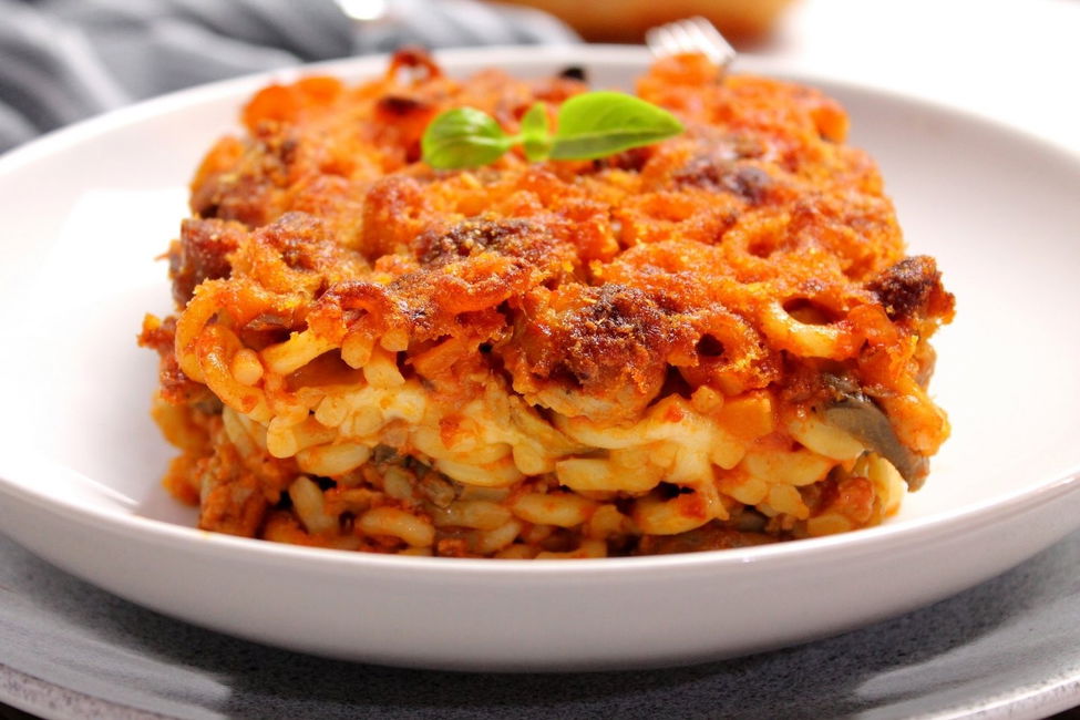 Timballo di anelletti al forno con funghi, salsiccia e mozzarella