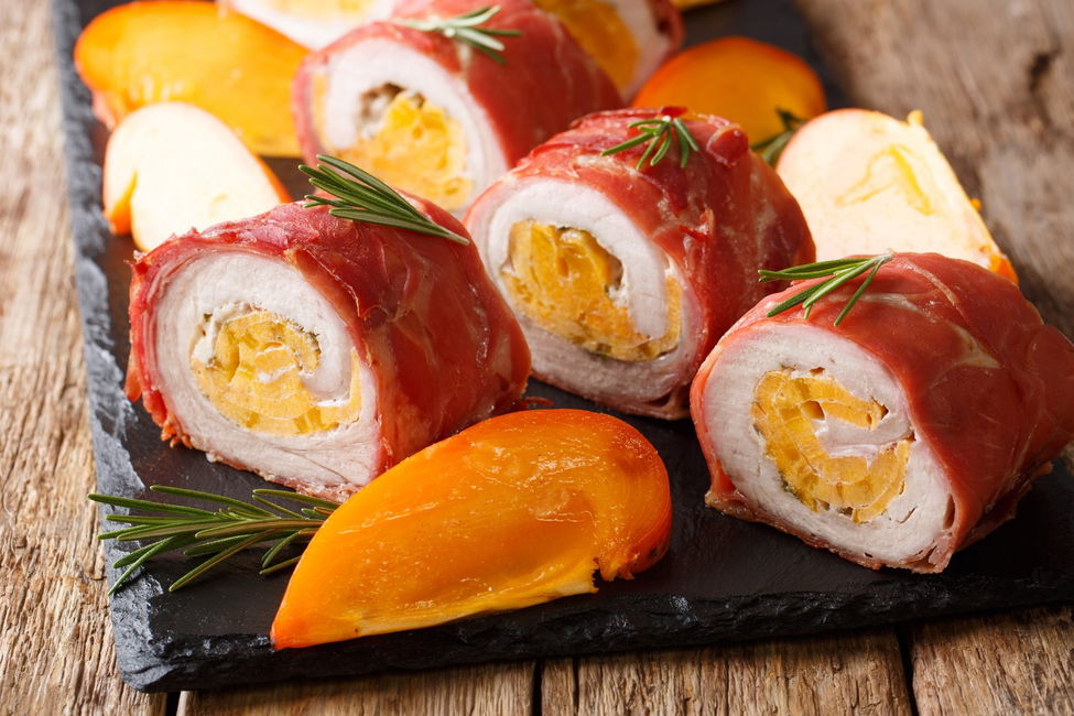 Rotolini di maiale avvolti nel prosciutto, farciti con cachi e caprino