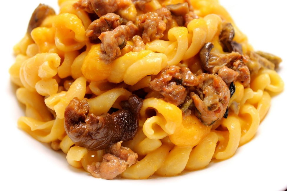 Fusilloni con crema di zucca, salsiccia e funghi misti secchi