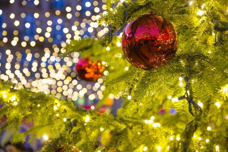 Weihnachtsbaum mit Christbaumkugeln und Lichterkette auf einem w
