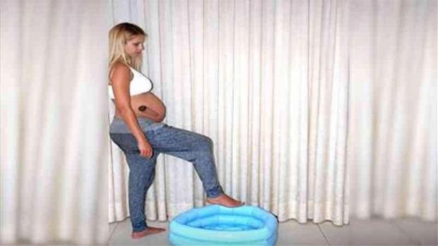 Una donna incinta entra in una piscina gonfiabile. Guardate cosa succede ai suoi pantaloni quando esce fuori!