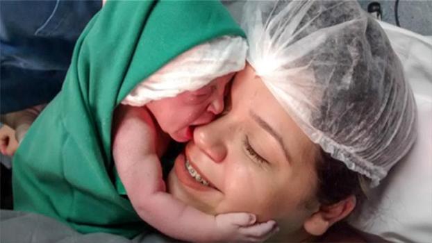 Subito dopo la nascita, questa bimba si aggrappa al viso della mamma. Davvero commovente!