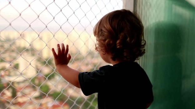 Bimbo di 2 anni a penzoloni sul balcone, la vicina lancia l’allarme. La mamma si difende: "Volevo educarlo"